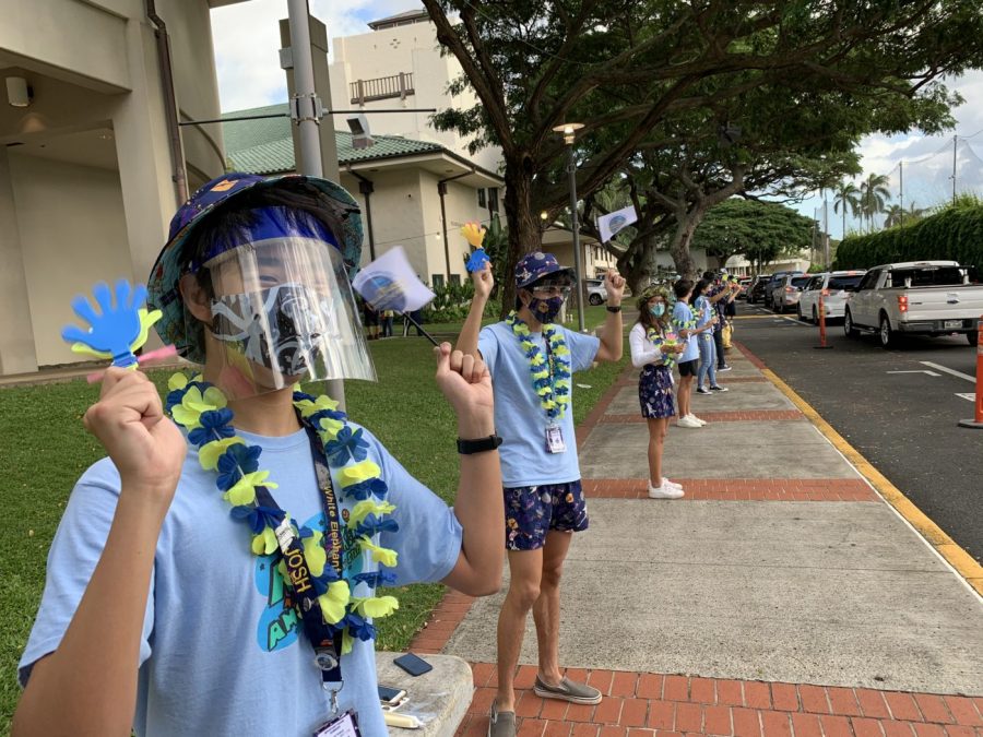 Josh Lee 22 and Kainoa Paul 22 wave to cars waiting in line for the drive-in movie. Photo Courtesy of Punahou School.