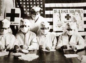 Medical personnel sit in front of an American flag
