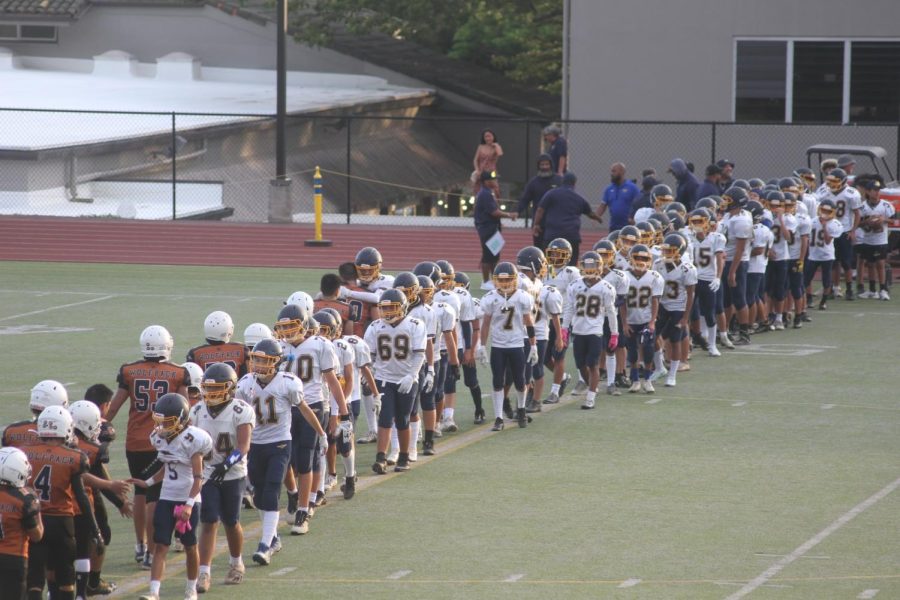Photo+of+football+field+seen+from+bleachers.+Punahou+and+Pac-5+intermediate+football+field+are+walking+in+line+across+the+field+to+shake+hands.